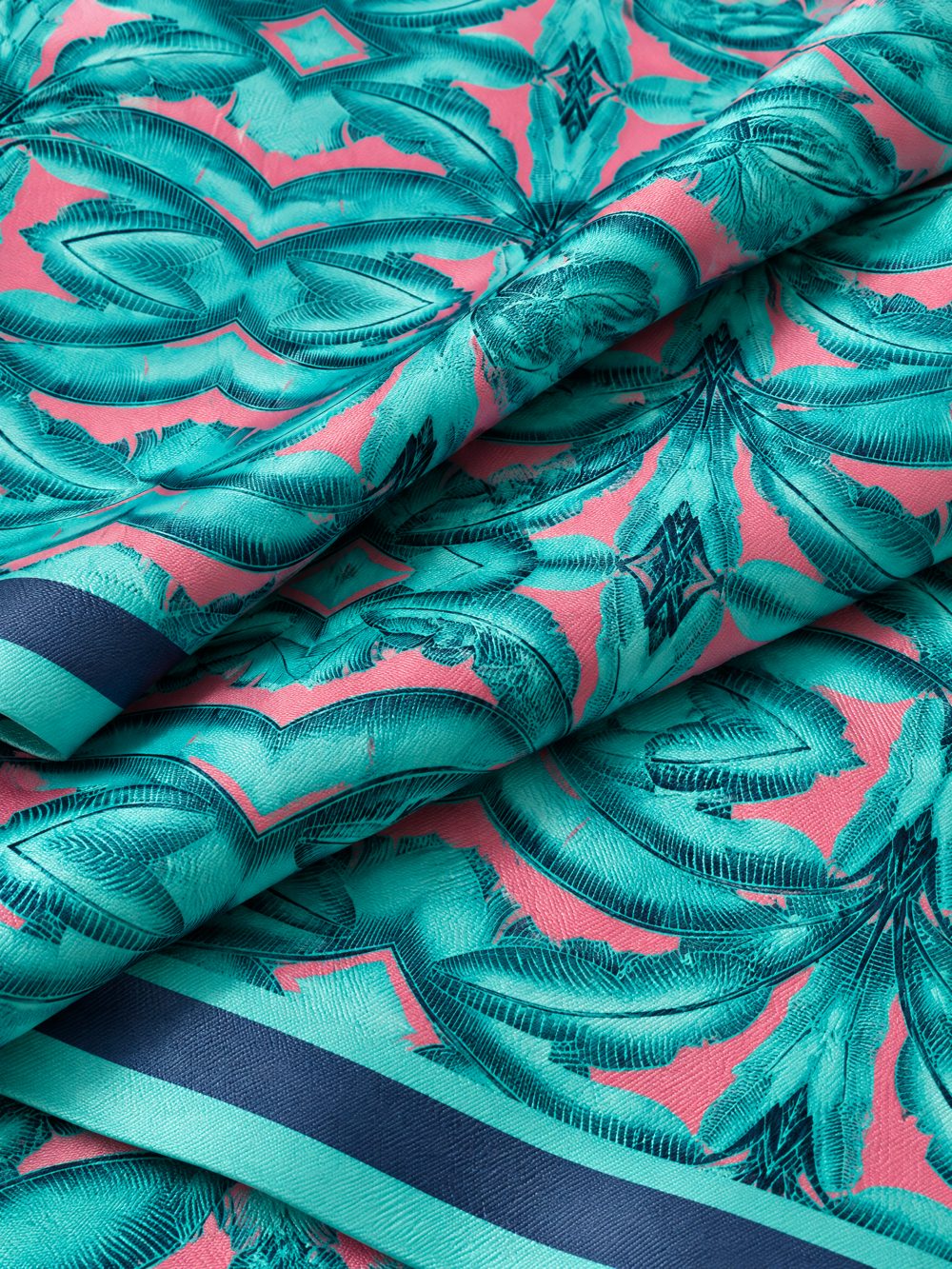 Close-up of Banana Leaves in Jade and Pink printed on folded fabric