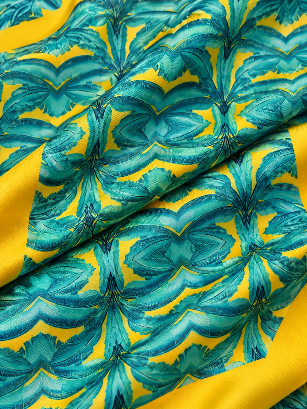 Close-up of Banana Leaves in Jade and Yellow printed on folded fabric