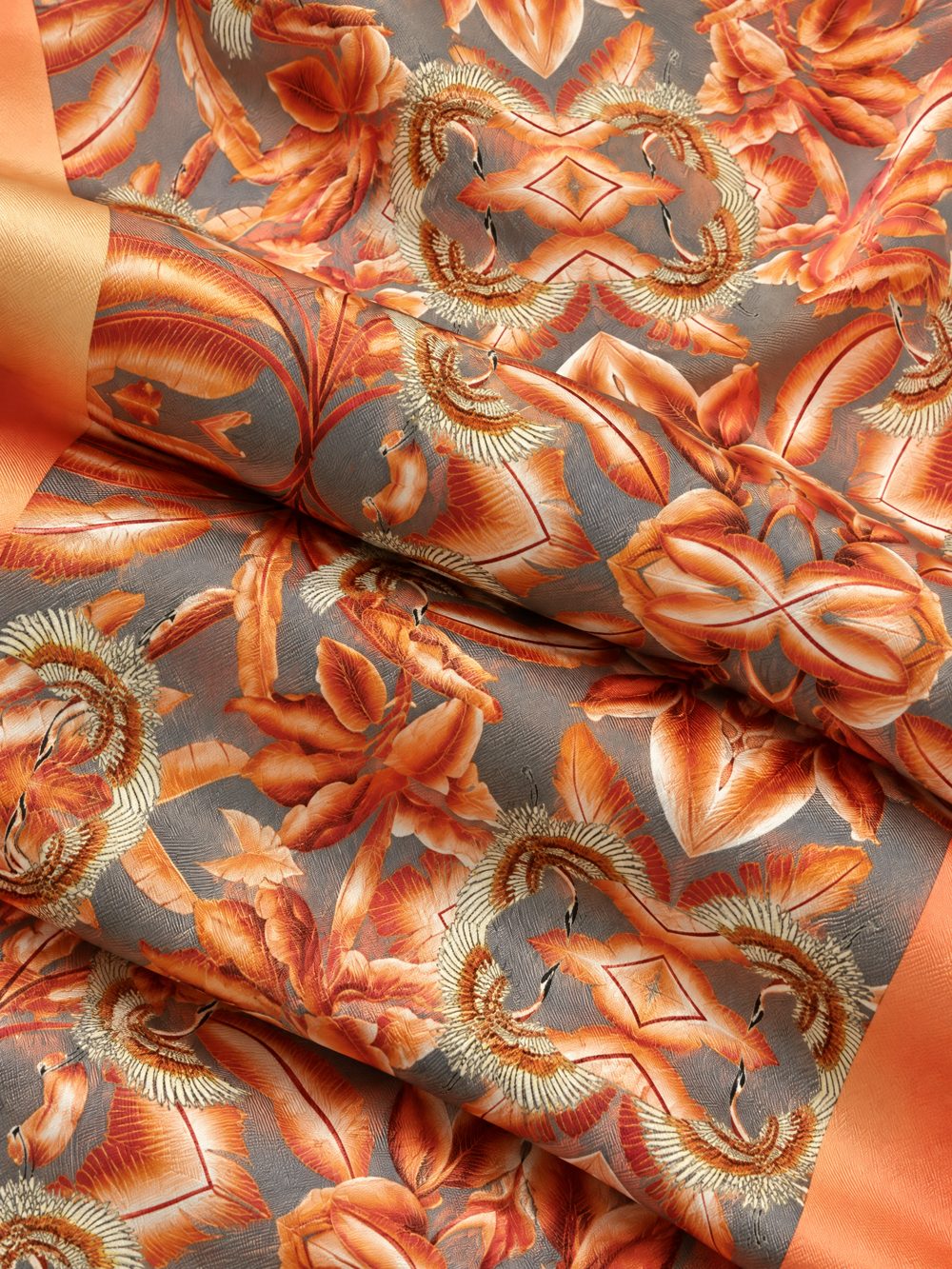 Close-up of Golden Cranes Orange Leaves printed on folded fabric
